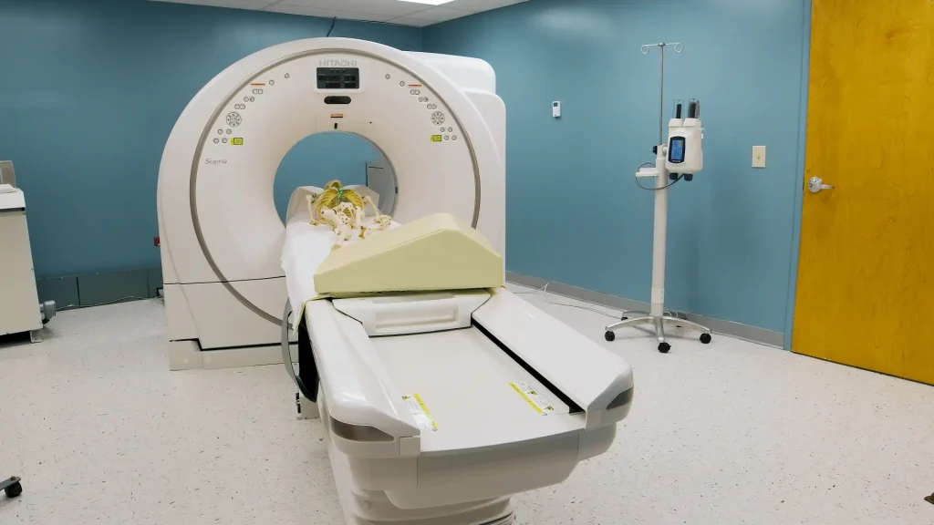 Fujifilm Supria True64 CT scanner in an exam room with a skeleton model positioned on the table