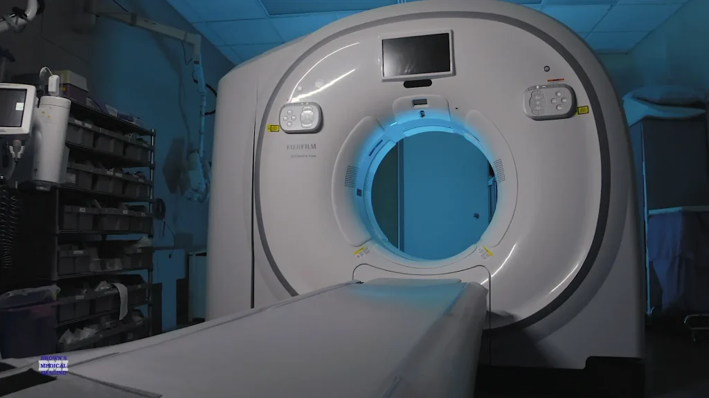 Fujifilm Scenaria View CT scanner with blue-lit bore and patient table in a dim exam room