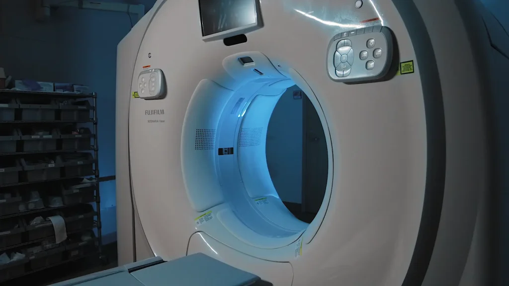 Close-up of a Fujifilm Scenaria View CT scanner gantry bore illuminated in blue