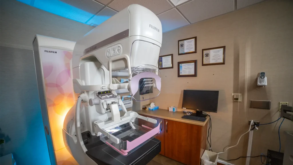 Fujifilm ASPIRE Cristalle mammography system in a clinic exam room with certificates on the wall