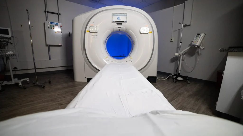 Fujifilm Scenaria View 128 CT scanner with illuminated blue bore opening in an exam room