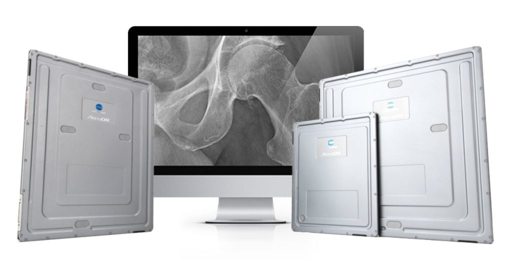 Three AeroDR detector panel sizes displayed in front of a monitor showing a hip X-ray image