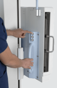 Close-up of a technologist operating the wall stand detector's control panel on the Essentia FS