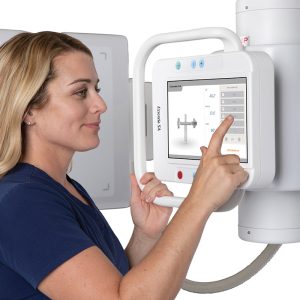 Close-up of a technologist adjusting exposure settings on the Essentia SA tube head's touchscreen control panel