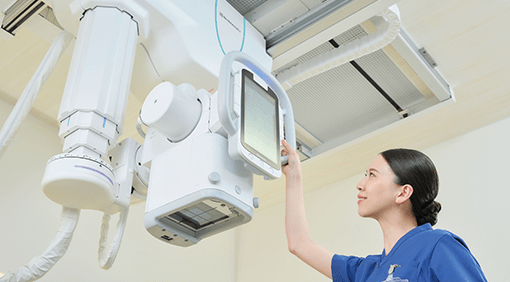 Technologist adjusting the overhead tube head touchscreen display on the RADspeed Pro SR5 system