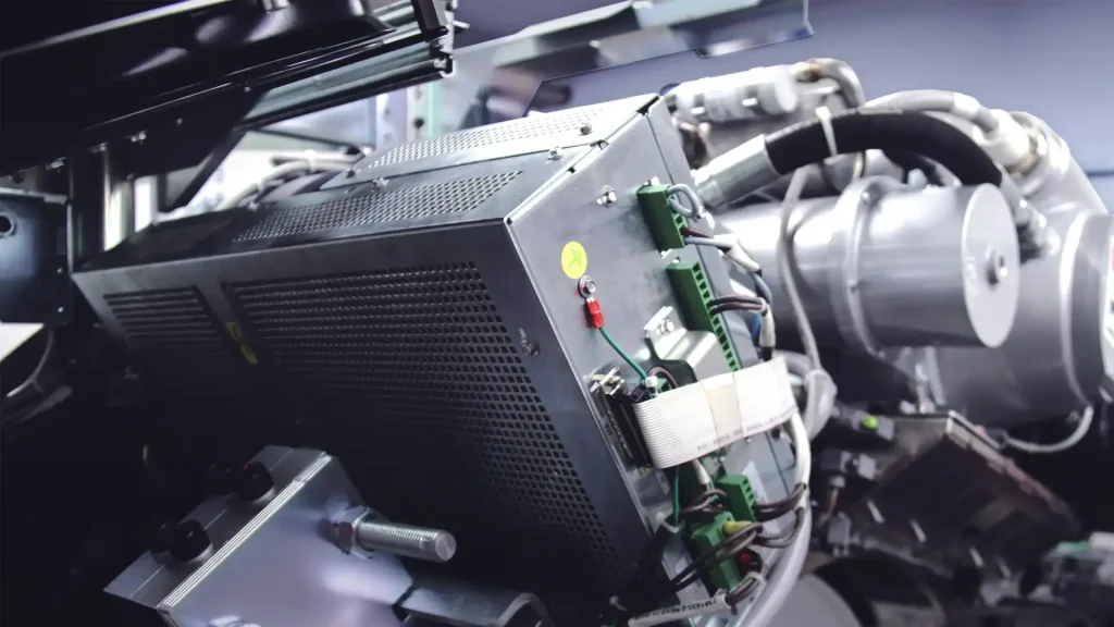 Close-up of internal CT scanner components including circuit boards, wiring, and a motor assembly