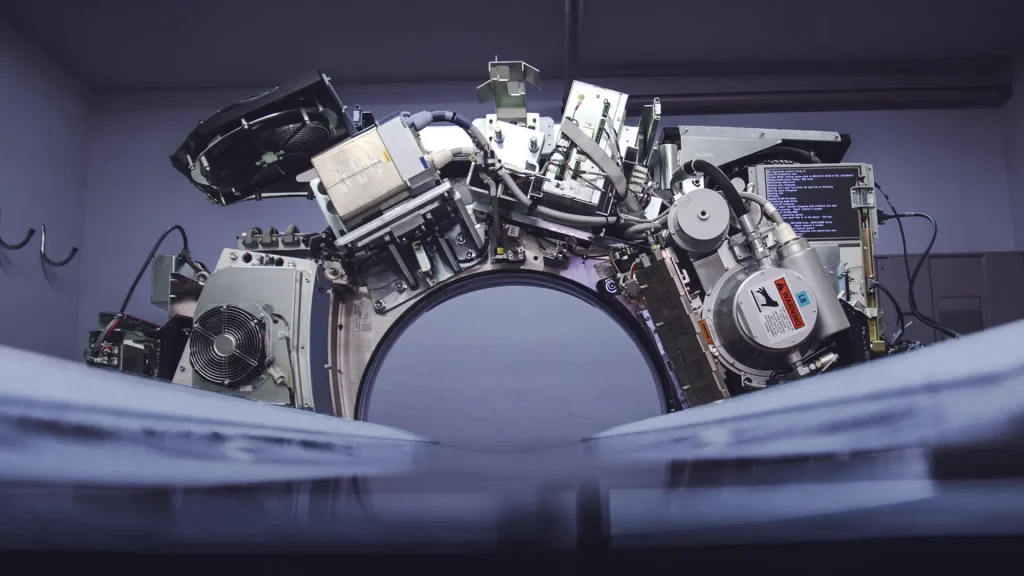 Close-up of open MRI/CT gantry internals showing wiring and circuit boards