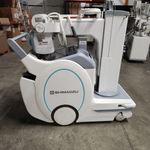 Shimadzu mobile X-ray unit, side view showing tube column and wheeled base in warehouse