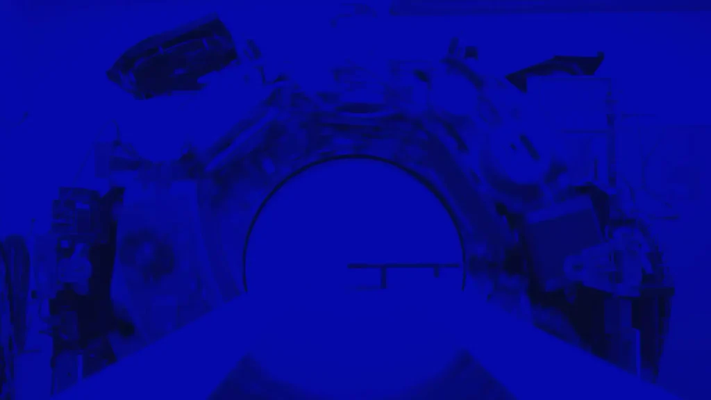 Interior view of a CT scanner gantry bore with a blue color tint
