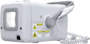 Side view of a portable X-ray generator housing showing the collimator lens, warning labels, and hand switch cable